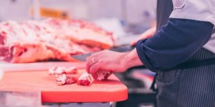 Boucher qui coupe la viande