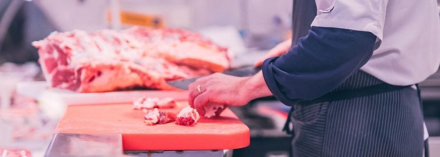 Boucher qui coupe la viande